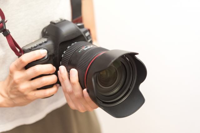 一眼レフカメラを持つ手