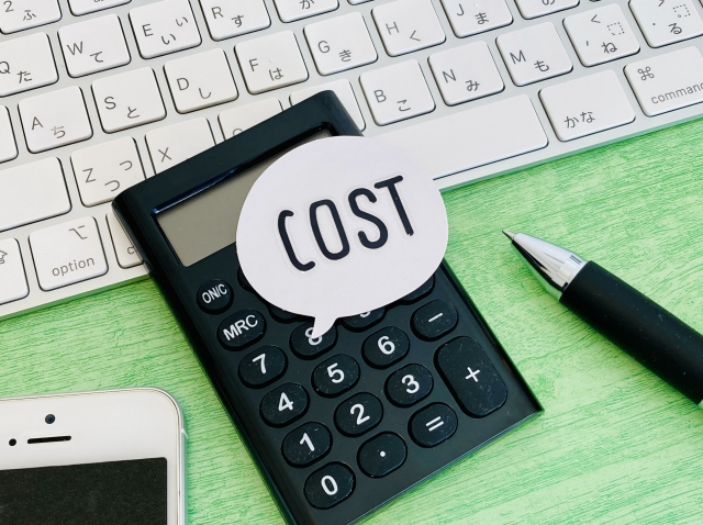 COSTの文字列とスマホとボールペン